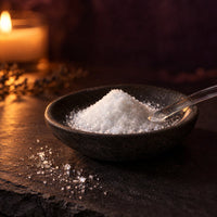 Gluconolactone, a fine white crystalline powder, in a stone dish